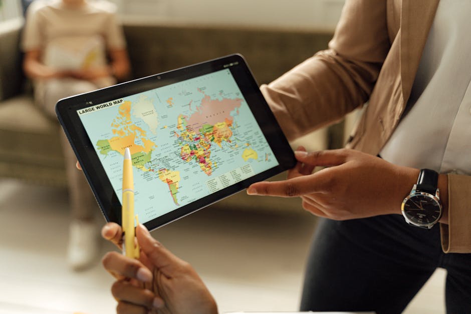 Close-up of hands holding a digital tablet displaying a world map