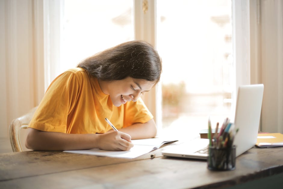 Young woman studying with a laptop and notepad at home