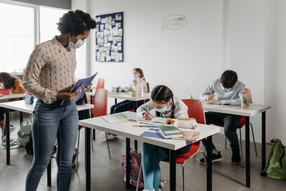 Students and teacher wearing masks in a diverse, modern classroom, focusing on education