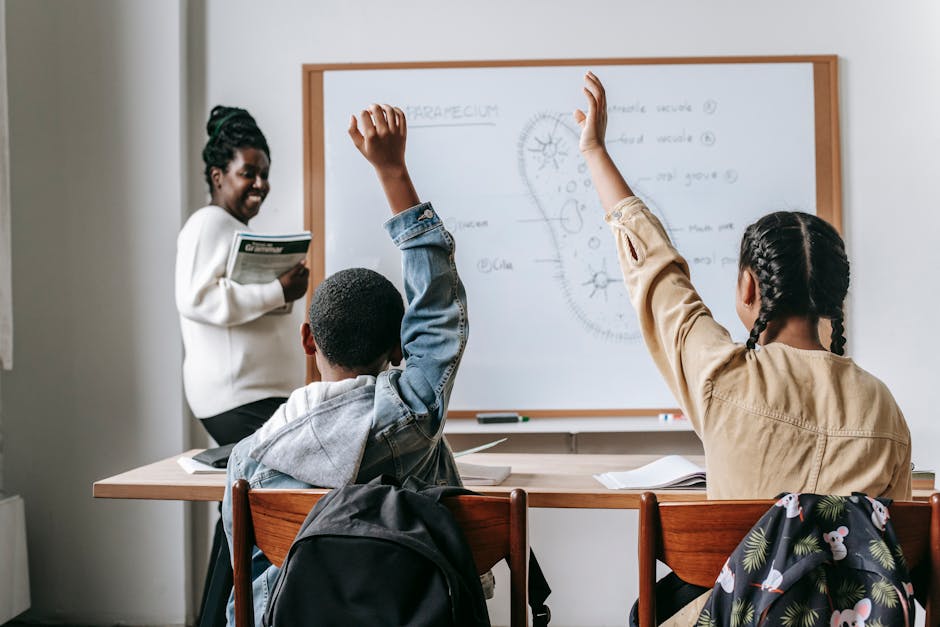 Students actively participating in a biology lesson with a teacher explaining at the whiteboard