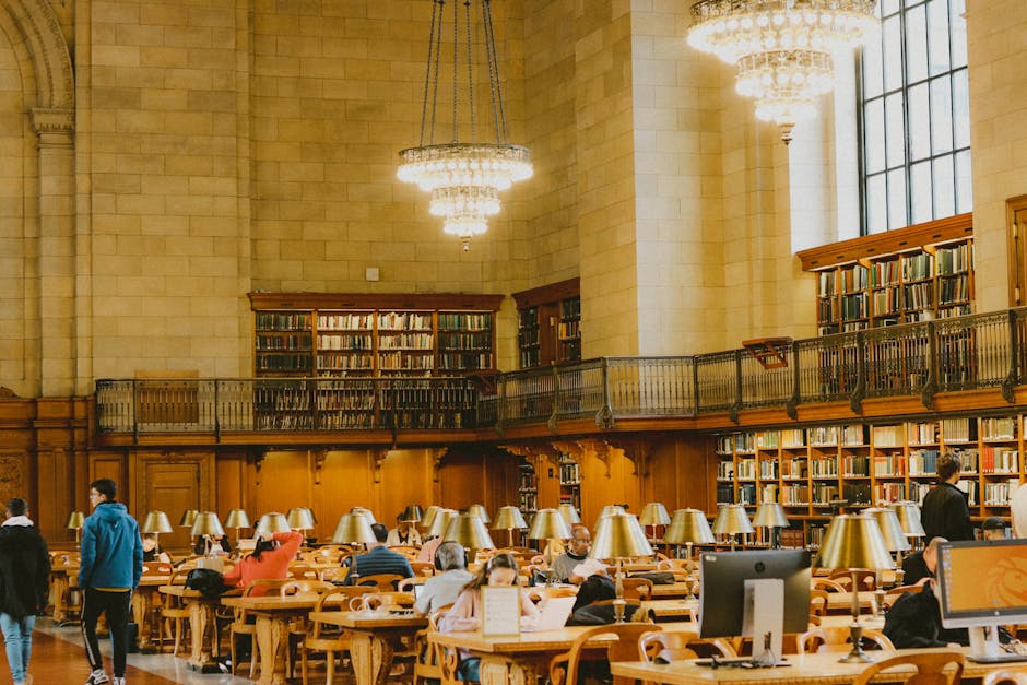 Spacious and elegant library interior with chandeliers and people studying at wooden tables